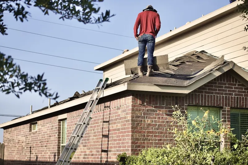 Professional roofer working on a residential roof in Audubon